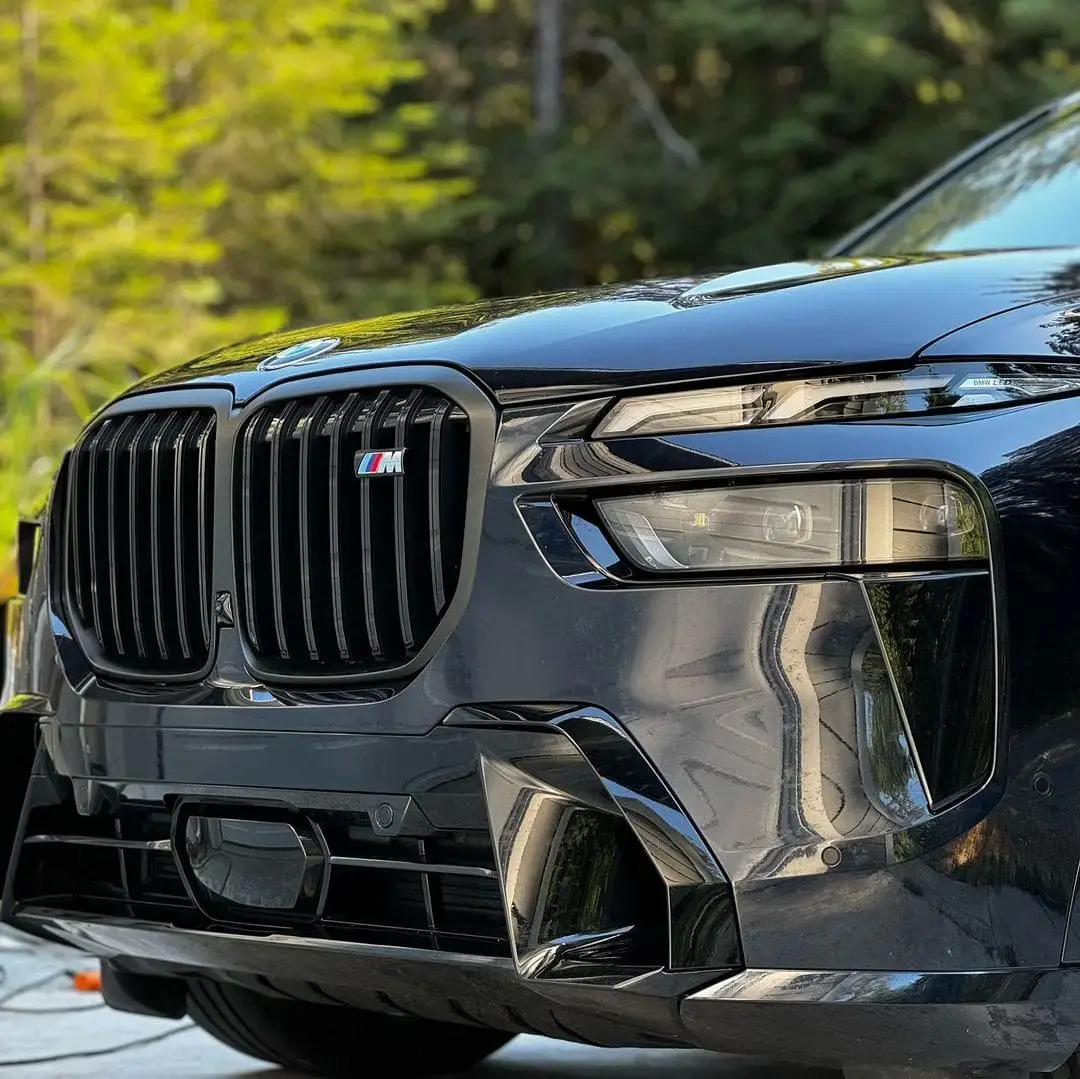 Close-up of a black BMW SUV’s front grille, highlighting its sleek and polished design.