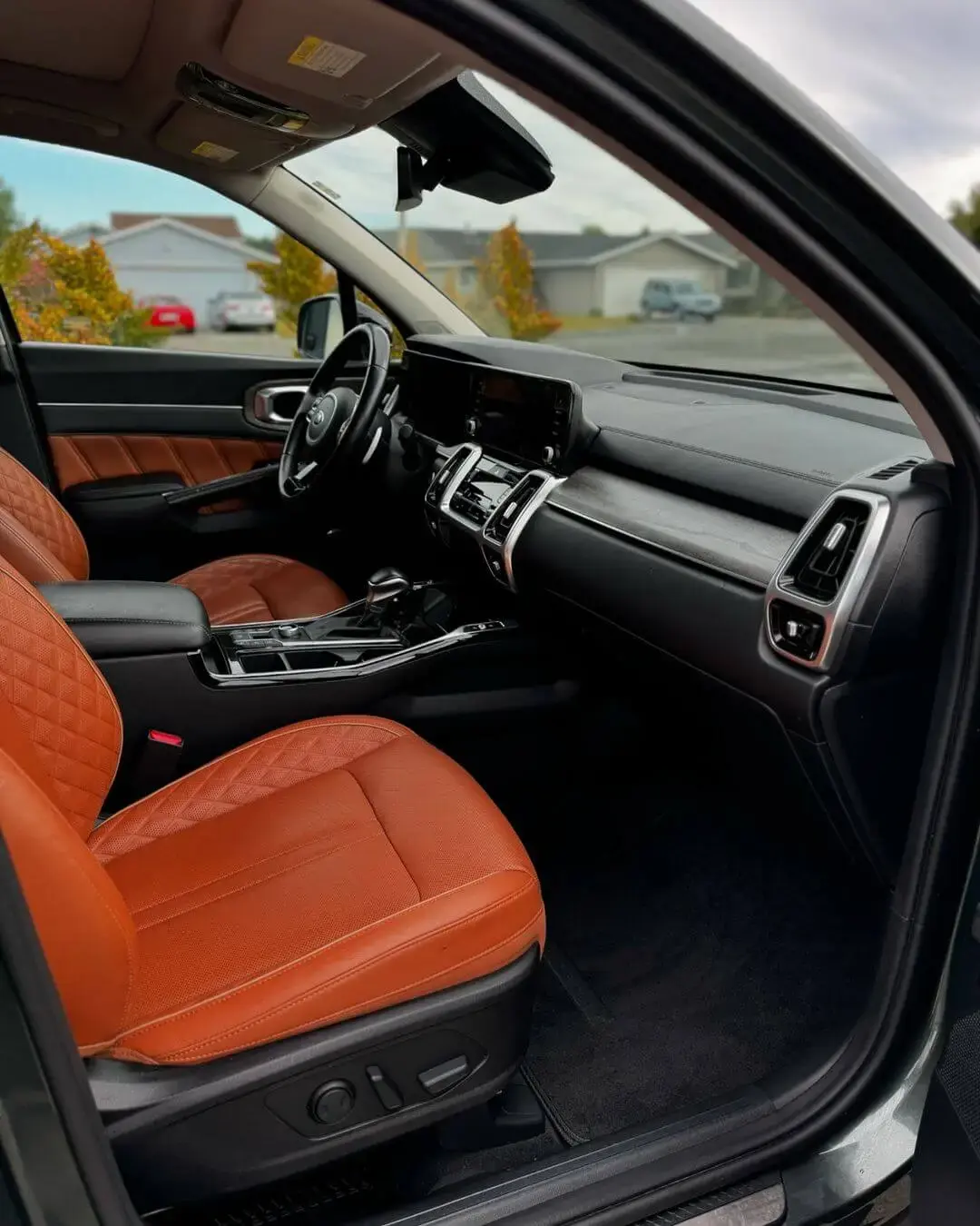 Interior view of a vehicle showcasing clean orange leather seats, a spotless dashboard, and a well-maintained cabin