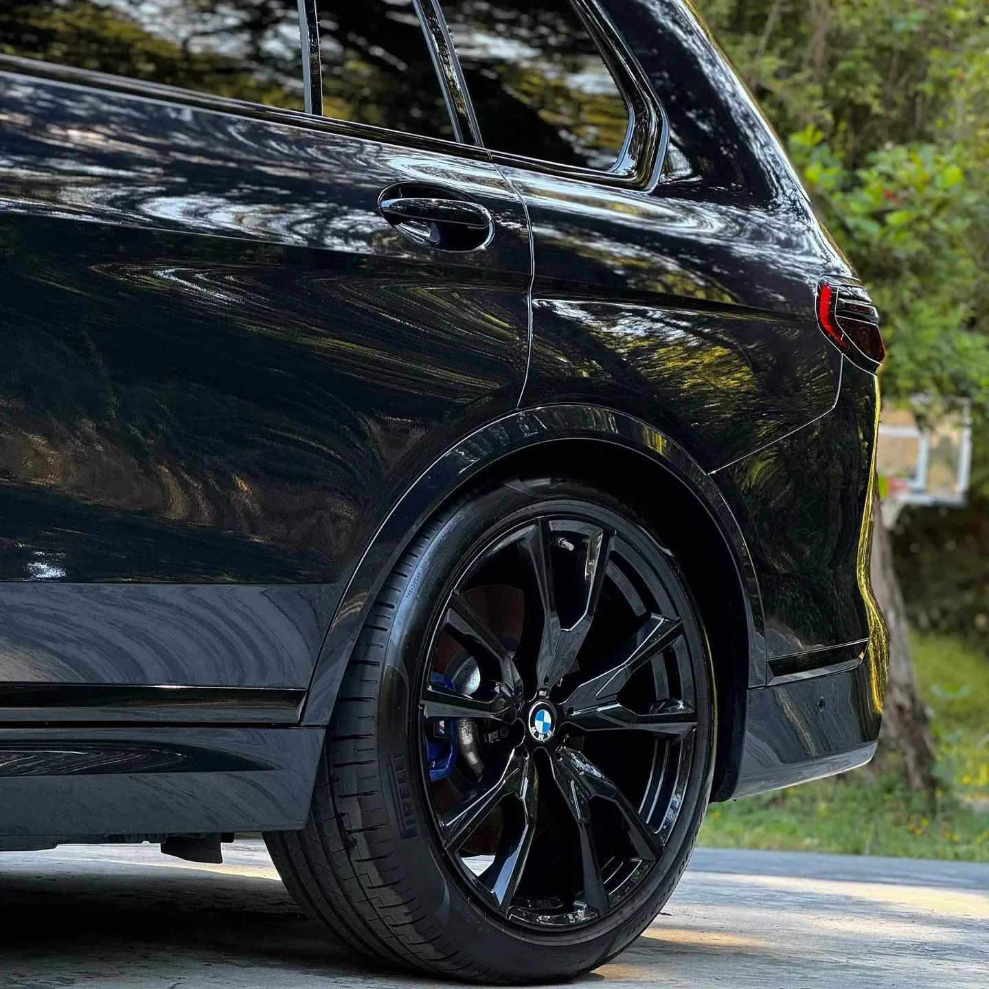 Side profile of a black BMW SUV with a glossy finish, showcasing the detailed exterior.